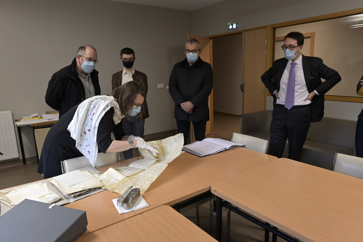Madame Longeard, directrice des Archives Départementales découvre les documents devant Monsieur CARO, maire de Quintin, Monsieur LECOQU conseiller départemental et Monsieur CARPO directeur de l'Hôpital.