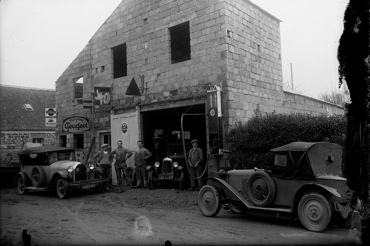 Des artisans posent avec leurs automobiles devant le garage Peugeot à Ploumilliau. (AD22, Fonds Kerdudo, 89 Fi 4262)