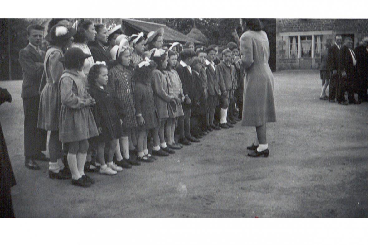 Les écoliers des Champs-Géraux chantent la Marseillaise, 14 juillet 1947 (AD 22, 126 J).